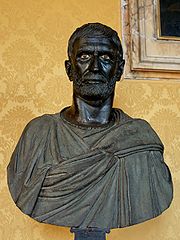 Buste en bronze, Brutus barbu, le visage fermé, le regard perçant.