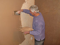 Plasterer at work on a wall arp.jpg