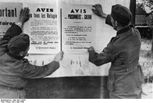 photographie des archives allemandes représentant l'affichage d'avis par l'armée d'occupation allemande