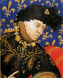 Enluminure représentant le portrait de Charles VI vêtu de noir à liseré or, chapeau noir, sur fond bleu à fleur de lys.