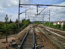 Bifurcation à l'ouest de la gare de Conflans-Sainte-Honorine, entre la ligne se dirigeant vers Mantes-Station et, à droite, une jonction permettant de rejoindre la ligne d'Achères à Pontoise.
