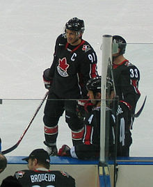 Photo de Sakic portant le maillot de l'équipe du Canada avec le numéro 91 et le C de capitaine.