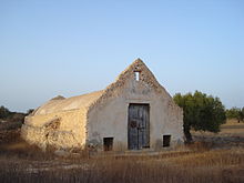 Vieux bâtiment longiligne servant comme atelier de tissage traditionnel.