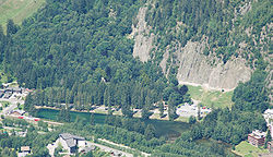 Vue du lac des Gaillands au centre, du rocher d'escalade des Gaillands en haut à droite, et d'une automotrice Z 800 de la ligne Saint-Gervais - Vallorcine en bas à gauche.