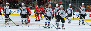 Photo de joueurs de l'Avalanche et des Flames de Calgary en arrière plan.