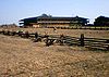 Photograph of the Petaluma Adobe, a broad, low, two-story building with wide verandas amidst open grasslands.