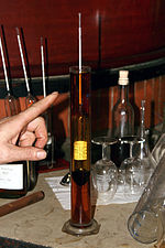 Photographie d'un alcoomètre du début du vingtième-et-unième siècle en train de mesurer le degré d'alcool d'un cognac.