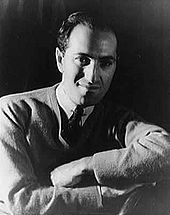 Photographie noir et blanc représentant le compositeur George Gershwin en buste de face les bras croisés