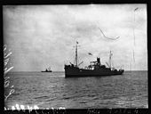 Photographie en noir et blanc de deux navires, au premier plan sur la droite, à l'arrière plan sur la gauche.