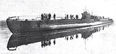 Photographie en noir et blanc d'un sous-marin, vu de bâbord avant.