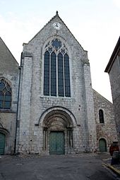 façade de l'église Saint-Nicola de saint-Arnoult-en-Yvelines montrant un portail de style roman surmonté d'une haute verrière