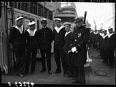Photographie en noir et blanc de six marins, sur le pont d'un navire.