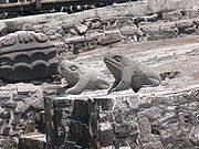Deux crapauds stylisés, sculptés dans de la pierre grise