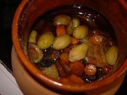 Dans un plat en terre cuite vernissée, les morceaux de viande et légumes carottes, pomme de terre) ont mijoté dans le vin rouge.
