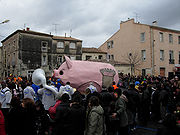 Une foule promenant un gros cochon rose en carton pâte