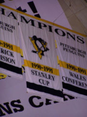 Photographie de bannières des titres gagnés en 1990-1991 par les Penguins de Pittsburgh.