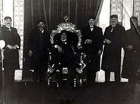 Ahmed II Bey entouré de membres de la cour beylicale dont le futur Moncef Bey alors prince héritier (premier à gauche du trône)