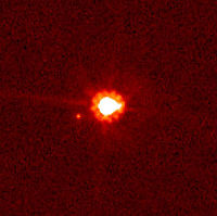 Éris (centre) et sa lune Dysnomie (sur sa gauche), photographiés par le télescope spatial Hubble.