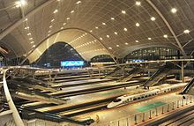 Intérieur de la gare avec les voies et les quais couverts.