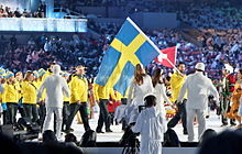 Photo de l'équipe de Suède qui défile lors de la cérémonie d'ouverture des Jeux olympiques, Forsberg en tête portant le drapeau suédois.