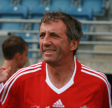 Portrait large d'Alan Kennedy qui porte le maillot rouge du Liverpool Football Club.