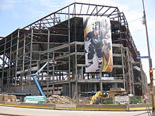 Photo de la structure du Consol Energy Center pendant sa construction ; une affiche géante représentant Sidney Crosby y est accrochée.