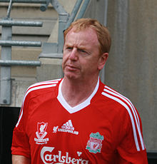 Portrait large de David Fairclough avec un maillot rouge du Liverpool Football Club, club dans lequel il a évolué comme joueur de football.