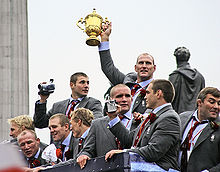 Photo des joueurs anglais célébrant leur victoire à bord du bus qui les fait défiler dans Londres.