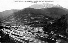 Carte postale ancienne montrant l'ensemble de la gare, le village et la montagne