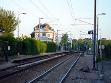 Vue d'ensemble de la gare, avec les deux voies, les deux quais et le bâtiment voyageurs