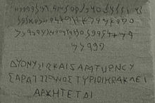 Agrandissement de l'inscription bilingue gréco-phénicienne se trouvant sur la base du cippe présenté ci-avant. Le phénicien est au-dessus, le grec en-dessous, gravé en capitales permettant de bien distinguer la présence des voyelles qui furent créées par les Grecs.