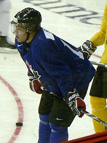 Photographie couleur de Taylor Hall sur la glace portant un maillot bleu d'entraînement de l'équipe du Canada