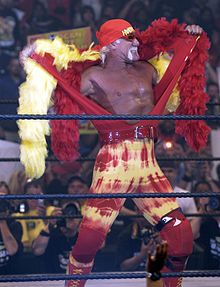 Hulk Hogan sur le ring, en train de retirer son manteau jaune et rouge.