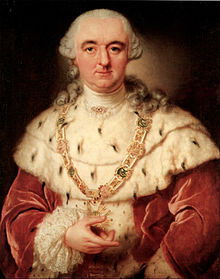 A bewigged man wears an ermine stole, and a crimson robe.