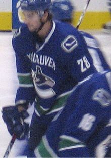Photo floue de Bourdon avec le maillot bleu numéro 28 des Canucks de Vancouver.