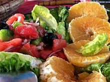 Salade composée de salade, tomates, oranges, olive noire.