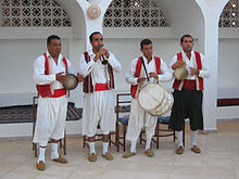 Groupe de quatre musiciens djerbiens jouant (de gauche à droite) du bendir, de la zoukra, du tabl et du darbouka.