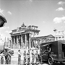 Photographie de soldats faisant la file devant une camionnette-cantine près de la porte de Brandebourg
