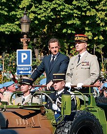Photographie du président français Nicolas Sarkozy et du général Jean-Louis Georgelin, chef d'état-major des armées, passant en revue les troupes lors du défilé du 14 juillet 2008 sur les Champs-Élysées.