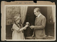 Katie Ruder (Dorothy Gish) offre un bouquet de fleurs au Prince Karl Heinrich (Wallace Reid).