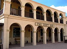 Photographie des studios Old Tucson, on y voit un bâtiment avec un vaste balcon au premier et dernier étage, et le rez de chaussée est marqué par un couloir