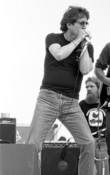 Photographie montrant Paul Butterfield sur scène, micro dans les mains, en tshirt et jean.
