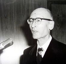 Photographie noir et blanc de Robert Rumilly lors d'une conférence de presse en 1977.