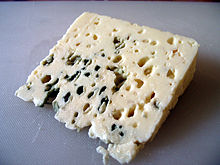 La photographie couler présente un quartier fin de fromage. L'affinage est à un stade jeune ; la couleur des moisissures n'est pas homogène, des veines sont restées blanches.