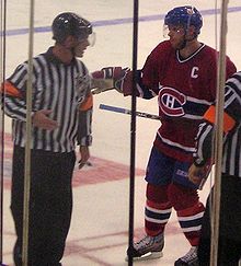 Photo de Saku Koivu dans la tenue des Canadiens de Montréal qui discute avec un arbitre.
