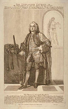 La photo monochrome montre une homme anglais habillé en tenue d'apparat du XVIIIe siècle et portant une perruque.