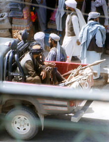 Talibans armés de fusils et de lances-roquettes installés à l'arrière d'un pick-up.