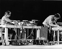 David Tudor à gauche et john Cage à droite en train d'utiliser des instruments électroniques