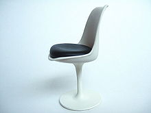 Miniature de la chaise Tulipe sur un fond blanc. Celle ci se compose d'un pied corolle blanc, d'une coque blanche incurvée. L'assise est noire.