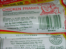 Photographie partielle d’un emballage souple en plastique blanc bordé de rouge et jaune, portant le nom et le logo de la marque en rouge, les indications d’ingrédients, l’adresse et le code barre en vert.